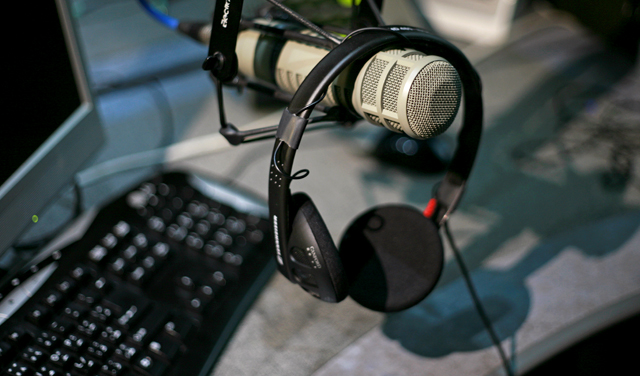 A set of headphones hanging over a microphone